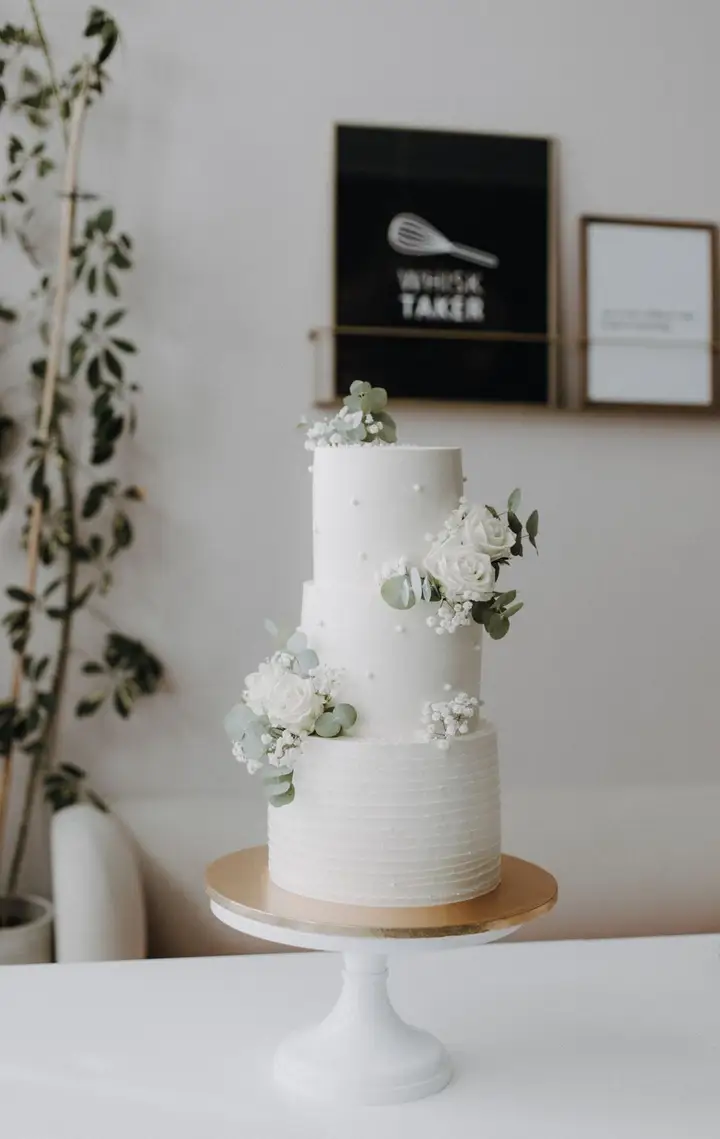 White celebration cake with fresh flowers
